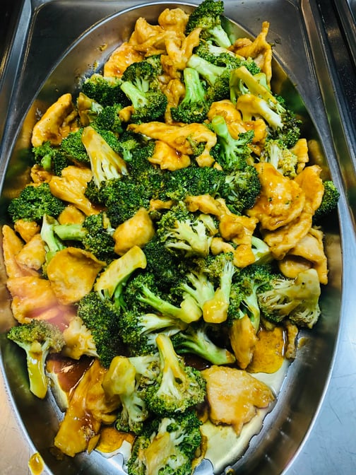 Chicken with broccoli in a steam-table pan